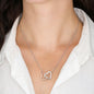 Woman wearing the silver Interlocking Hearts necklace with a white collared shirt