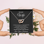 Two hands holding the To My Wife message card and necklace with white flowers