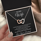 Hand holding the To My Wife Interlocking Hearts message card and necklace